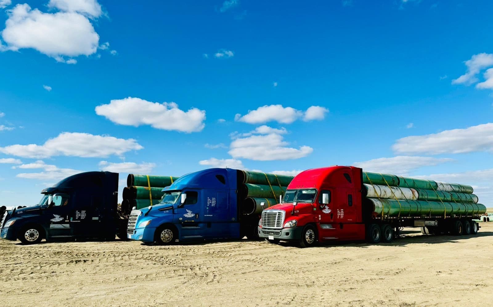 Flying Falcon flatbed trucks hauling pipe loads
